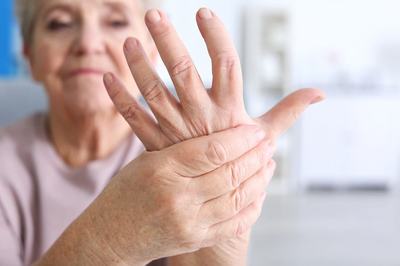 A female senior holding her hand with arthritis