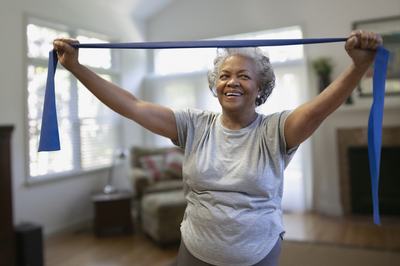 A female senior using a blue resistant band.
