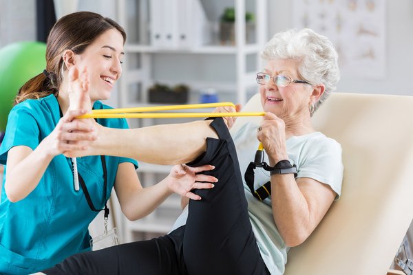 Physical therapist with senior working on leg exercises