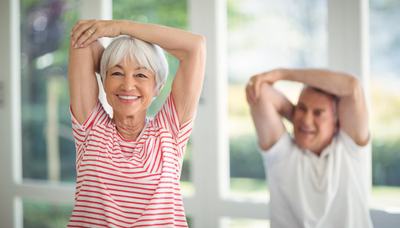 A female and male senior doing arm stretches