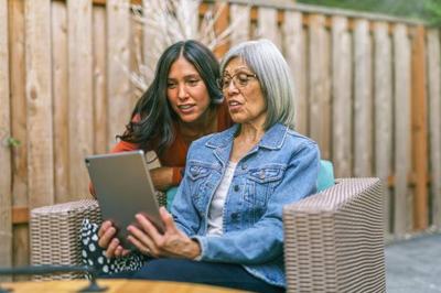 Senior female with adult daughter in front of a computer.