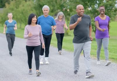 A group of seniors doing a power walk in the park.