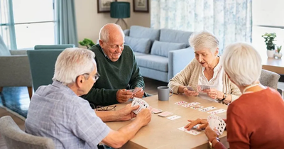 Seniors in an assisted living home playing cards
