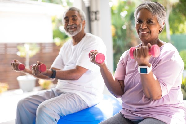 Two seniors, female and male, sitting on gymnastic balls working out