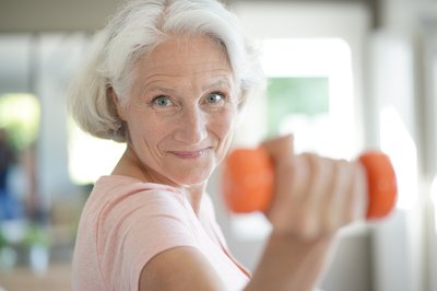 Female senior working with light dumbbell